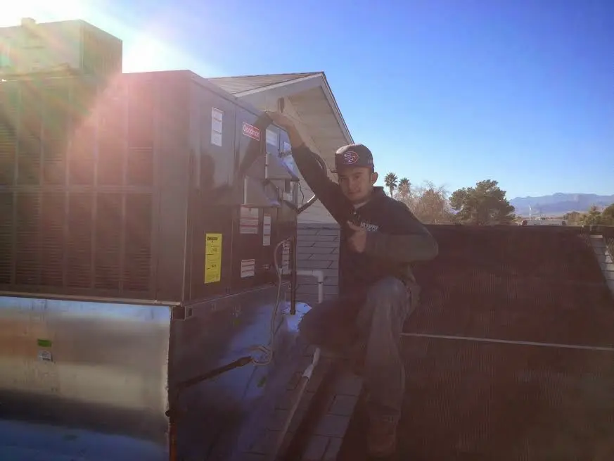 HVAC technician performing Boiler Repair on a rooftop unit in New Gloucester